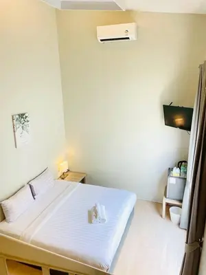 a bedroom with a white bed in a room at THE BELONG BOUTIQUE HOTEL in Phuket Town