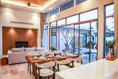 a dining room with a table and a couch at Shambhala grand villa by Cozy Lake in Bang Tao Beach
