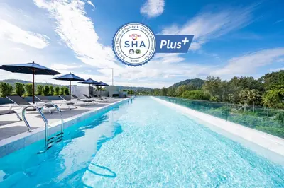 a swimming pool with chairs and umbrellas at a hotel at Kokotel Phuket Nai Yang Beach in Nai Yang Beach