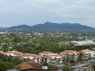 a city with houses and mountains in the background at Top Floor, One-Bedroom Apartment in Phuket Town
