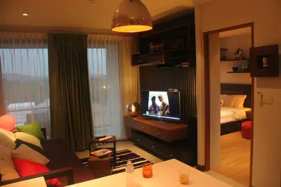 a living room with a television and a bedroom at Top Floor, One-Bedroom Apartment in Phuket Town