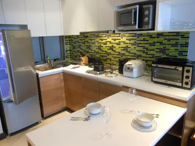 a kitchen with two plates and glasses on a table at Top Floor, One-Bedroom Apartment in Phuket Town