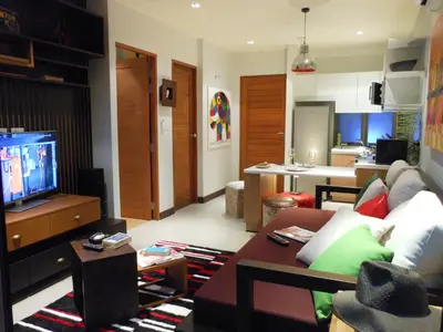 a living room with a couch and a tv at Top Floor, One-Bedroom Apartment in Phuket Town