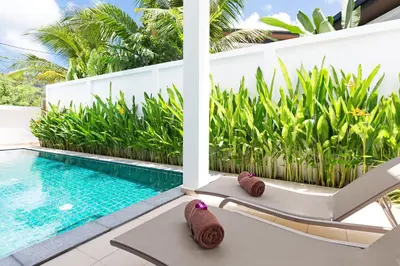 a villa with a swimming pool and a chaise lounge at Villa White Pool in Kamala Beach