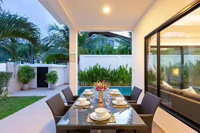 a dining table on the patio of a house at Villa White Pool in Kamala Beach