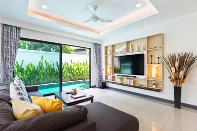 a living room with a couch and a tv at Villa White Pool in Kamala Beach