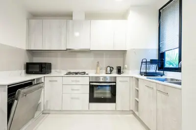 a kitchen with white cabinets and a stove top oven at Hot! Laguna Park 5BR Modern Pool Villa - Bangtao Beach in Bang Tao Beach
