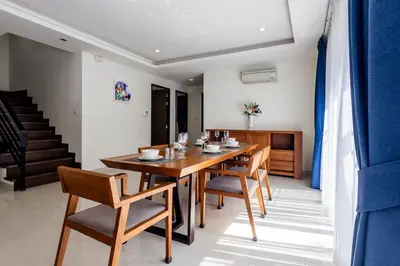 a dining room with a wooden table and chairs at Hot! Laguna Park 5BR Modern Pool Villa - Bangtao Beach in Bang Tao Beach