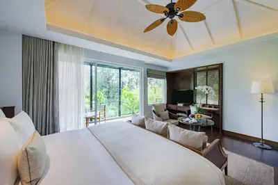 a bedroom with a large bed and a living room at Anantara Layan Phuket Resort in Layan Beach