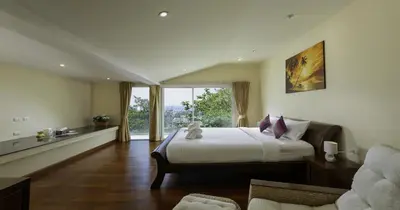 a bedroom with a large bed and a large window at Villa Yoosook in Patong Beach