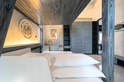 a bedroom with two beds and a clock on the wall at Villa Lami - Luxury 3-Bedroom Modern Villa in Phuket with Private Pool, Gym & Sauna in Phuket Town