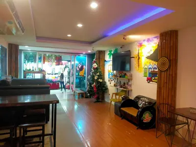 a living room with a christmas tree in the corner at Popeyes Hostel Patong in Patong Beach