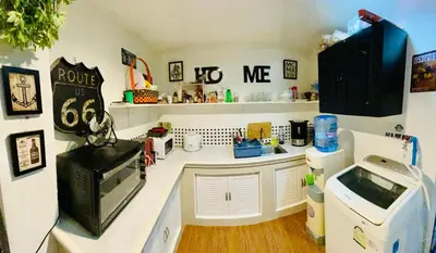 a kitchen with a counter with a sink and a microwave at Popeyes Hostel Patong in Patong Beach