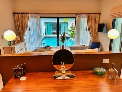 a bedroom with a large bed with a mirror on a table at Villa Tara nr Layan Beach in Bang Tao Beach