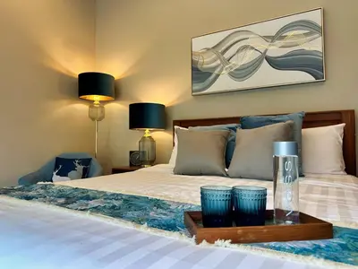 a bedroom with a bed with two blue glasses on a table at Villa Tara nr Layan Beach in Bang Tao Beach