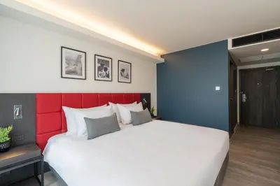 a bedroom with a large bed with a red headboard at Travelodge Phuket Town in Phuket Town
