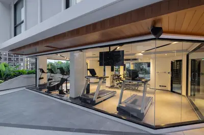 a gym with glass windows and exercise equipment at Travelodge Phuket Town in Phuket Town
