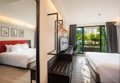 a hotel room with two beds and a mirror at Travelodge Phuket Town in Phuket Town