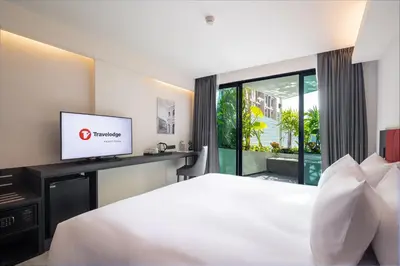 a hotel room with a bed and a tv at Travelodge Phuket Town in Phuket Town