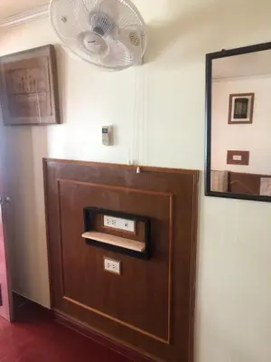 a brown door with a fan and a mirror at Phi Phi Dream Guest House in Phi Phi Don