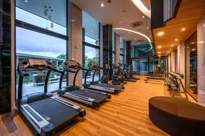 a row of treadmills in a gym with windows at Suite Vela 1BR Infinity Pool Mida Grande Surin in Surin Beach