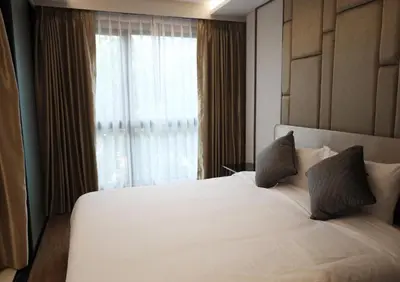 a bedroom with a large white bed with a window at Suite Vela 1BR Infinity Pool Mida Grande Surin in Surin Beach