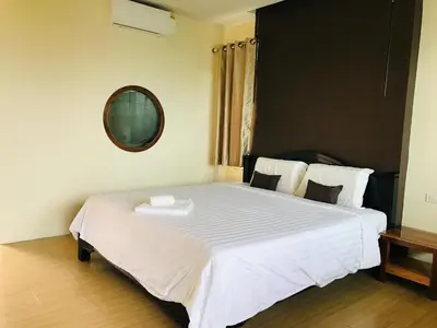 a bedroom with a large white bed with a mirror at Koh Yao Yai Sea Breeze House เกาะยาวใหญ่ซีบรีซเฮ้าส์ in Ko Yao Yai