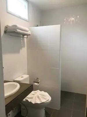 a white bathroom with a toilet and a sink at Koh Yao Yai Sea Breeze House เกาะยาวใหญ่ซีบรีซเฮ้าส์ in Ko Yao Yai