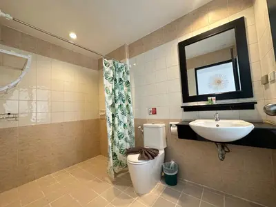 a bathroom with a sink and a toilet and a mirror at Hotel Baya Phuket in Patong Beach