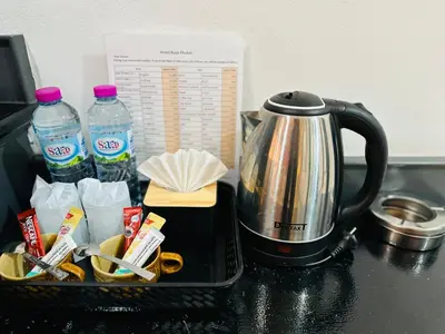 a toaster and a tea pot and water bottles on a counter at Hotel Baya Phuket in Patong Beach