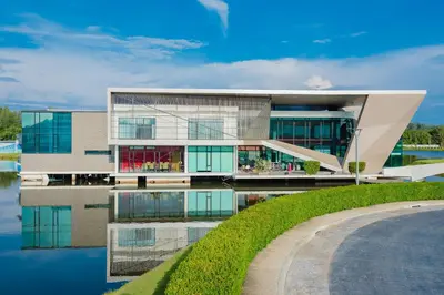 a building next to a body of water at Wyndham Phuket Airport in Nai Yang Beach