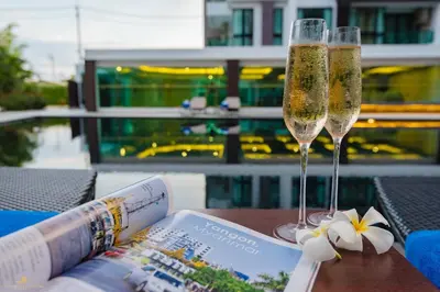 two champagne glasses sitting on a table next to a magazine at Wyndham Phuket Airport in Nai Yang Beach