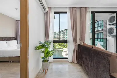 a bedroom with a bed and a large window at Wyndham Phuket Airport in Nai Yang Beach