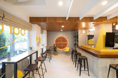 a restaurant with a bar with chairs and a counter at Bedline Hotel - SHA Certified in Phuket Town