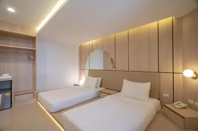 a room with two beds and a tv in it at Bedline Hotel - SHA Certified in Phuket Town