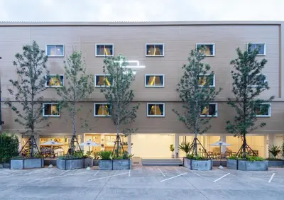 an exterior view of a building with trees in a courtyard at Bedline Hotel - SHA Certified in Phuket Town