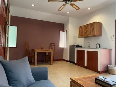 a living room with a couch and a kitchen at The Pace Phuket Boutique Resort in Rawai Beach