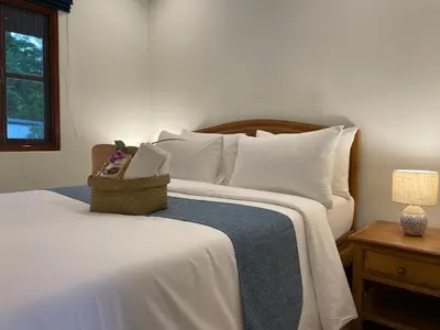 a white bed with a basket on top of it at The Pace Phuket Boutique Resort in Rawai Beach