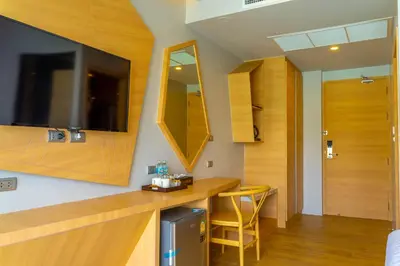 a room with a desk and a mirror and a door at Golden Paradise Hotel - SHA PLUS in Karon Beach