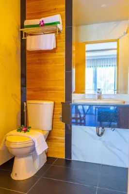 a bathroom with a toilet and a sink at Golden Paradise Hotel - SHA PLUS in Karon Beach