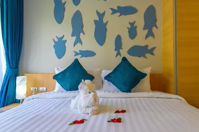a bedroom with a bed with stuffed animals on it at Golden Paradise Hotel - SHA PLUS in Karon Beach
