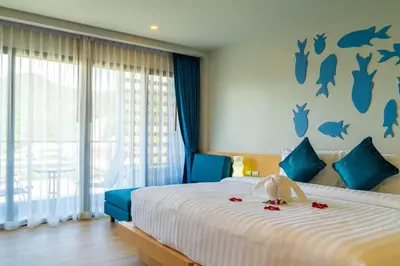 a bedroom with a bed with a teddy bear on it at Golden Paradise Hotel - SHA PLUS in Karon Beach