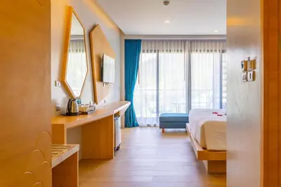 a hotel room with a bed and a mirror at Golden Paradise Hotel - SHA PLUS in Karon Beach