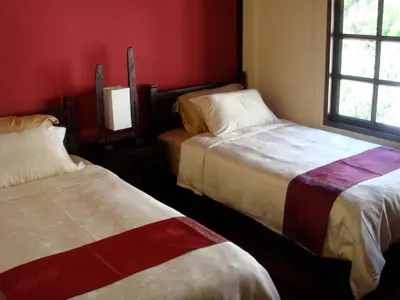 two beds in a room with red walls and windows at Sunset Apartment Phuket in Patong Beach