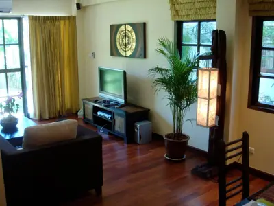 a living room with a flat screen tv and a couch at Sunset Apartment Phuket in Patong Beach