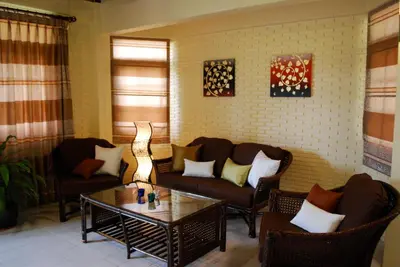 a living room with two couches and a coffee table at Sunset Apartment Phuket in Patong Beach