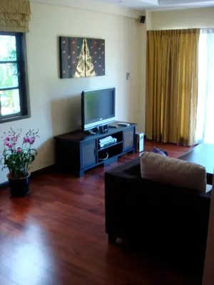 a living room with a couch and a flat screen tv at Sunset Apartment Phuket in Patong Beach