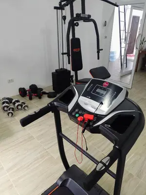 a gym with a treadmill and weights in a room at Hallo Patong Hotel in Patong Beach