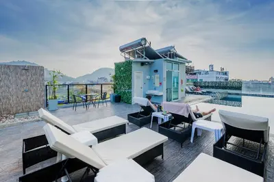 a patio with chairs and tables and a building at Hallo Patong Hotel in Patong Beach