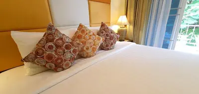 a hotel room with a bed with pillows on it at The Mareeya Place in Kamala Beach
